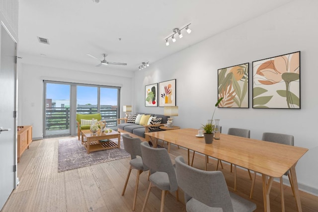 3600 S Lamar Blvd Unit 501, Austin, TX 78704 - dining room featuring light wood finished floors, a ceiling fan, and rail lighting