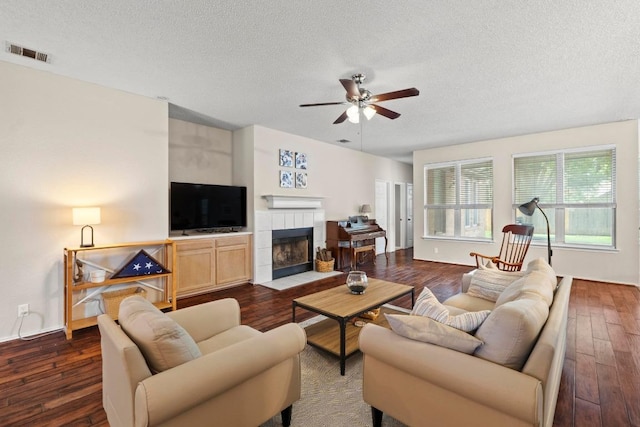 16907 Cranston Dr, Round Rock, TX 78664 - living area featuring a ceiling fan, a textured ceiling, dark wood-type flooring, and a fireplace