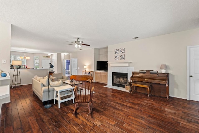 16907 Cranston Dr, Round Rock, TX 78664 - living area featuring hardwood / wood-style flooring, a ceiling fan, a tile fireplace, and a textured ceiling