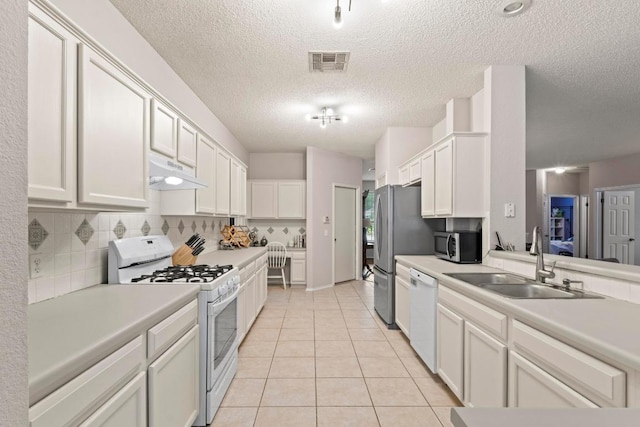 16907 Cranston Dr, Round Rock, TX 78664 - kitchen featuring stainless steel appliances, under cabinet range hood, light tile patterned floors, light countertops, and a textured ceiling