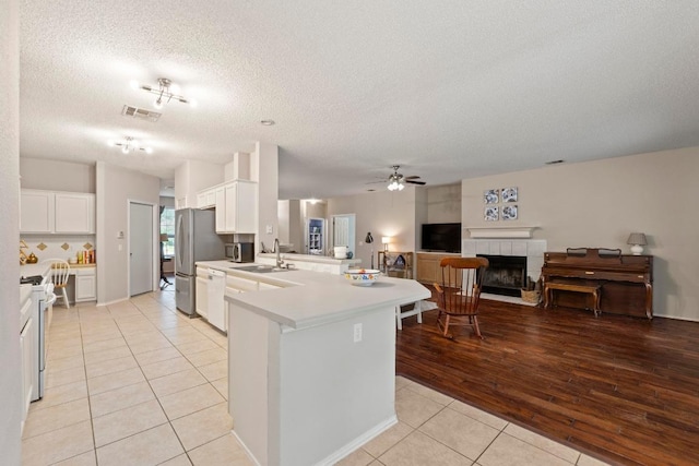 16907 Cranston Dr, Round Rock, TX 78664 - kitchen with light tile patterned flooring, a peninsula, white appliances, open floor plan, and a ceiling fan