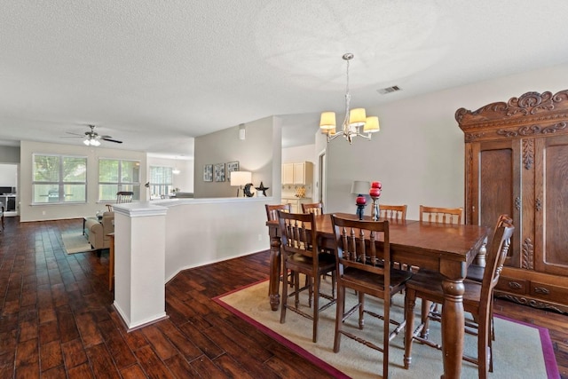 16907 Cranston Dr, Round Rock, TX 78664 - dining room with dark wood-style floors, a chandelier, a ceiling fan, and a textured ceiling