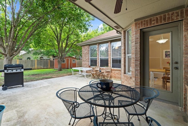 16907 Cranston Dr, Round Rock, TX 78664 - fenced backyard featuring a storage unit, outdoor dining area, a patio, area for grilling, and a ceiling fan