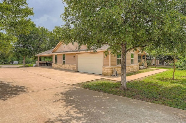 195 Heritage Oaks Dr, Cedar Creek, TX 78612 - view of front of house featuring stone siding, driveway, a garage, and a front yard