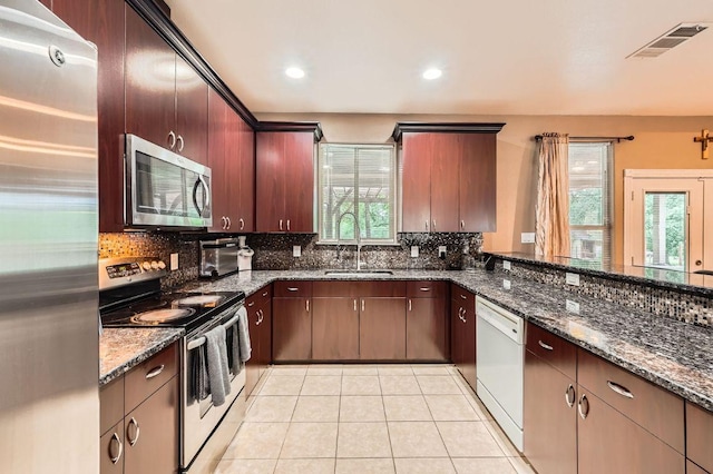 195 Heritage Oaks Dr, Cedar Creek, TX 78612 - kitchen featuring appliances with stainless steel finishes, healthy amount of natural light, tasteful backsplash, light tile patterned flooring, and recessed lighting