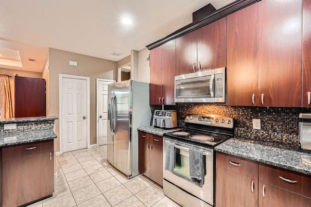 195 Heritage Oaks Dr, Cedar Creek, TX 78612 - kitchen with stainless steel appliances, decorative backsplash, light tile patterned floors, and dark stone counters