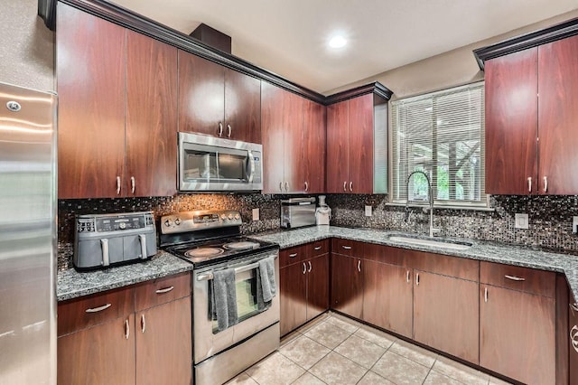 195 Heritage Oaks Dr, Cedar Creek, TX 78612 - kitchen with stainless steel appliances, light tile patterned flooring, decorative backsplash, and dark stone counters