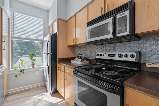 1201 Grove Blvd Unit 2203, Austin, TX 78741 - kitchen featuring stainless steel appliances, dark countertops, tasteful backsplash, and light wood-style flooring