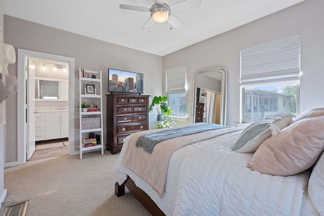 1201 Grove Blvd Unit 2203, Austin, TX 78741 - bedroom featuring light carpet, ceiling fan, and connected bathroom