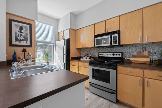 1201 Grove Blvd Unit 2203, Austin, TX 78741 - kitchen with electric stove, freestanding refrigerator, dark countertops, tasteful backsplash, and light wood finished floors