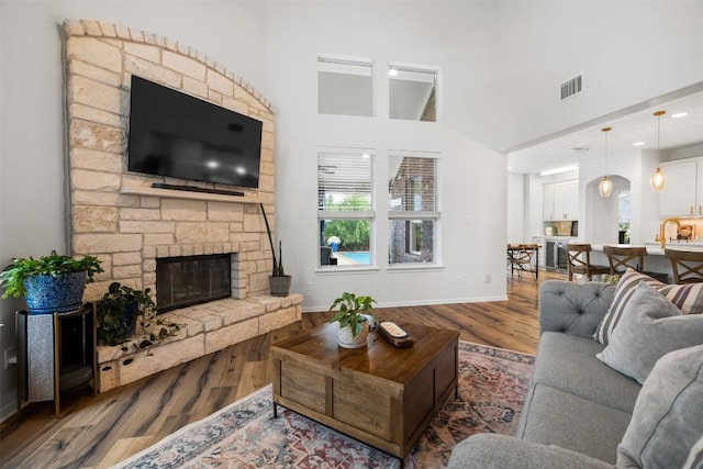 4539 Miraval Loop, Round Rock, TX 78665 - living area with wood finished floors, healthy amount of natural light, a stone fireplace, and a towering ceiling