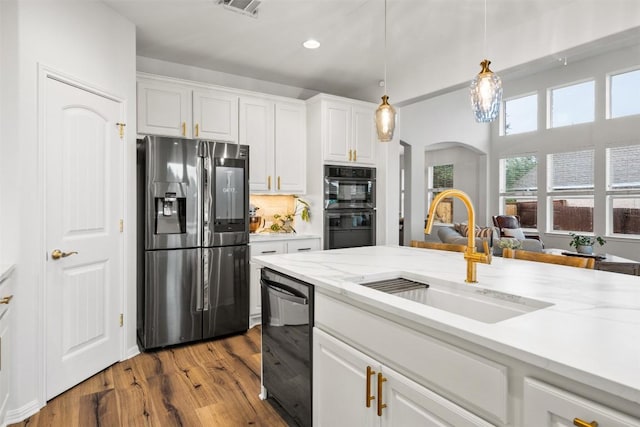 4539 Miraval Loop, Round Rock, TX 78665 - kitchen with stainless steel fridge with ice dispenser, dishwashing machine, arched walkways, dark wood-style flooring, and white cabinets