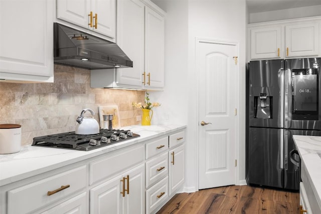 4539 Miraval Loop, Round Rock, TX 78665 - kitchen with fridge with ice dispenser, under cabinet range hood, stainless steel gas cooktop, and white cabinetry