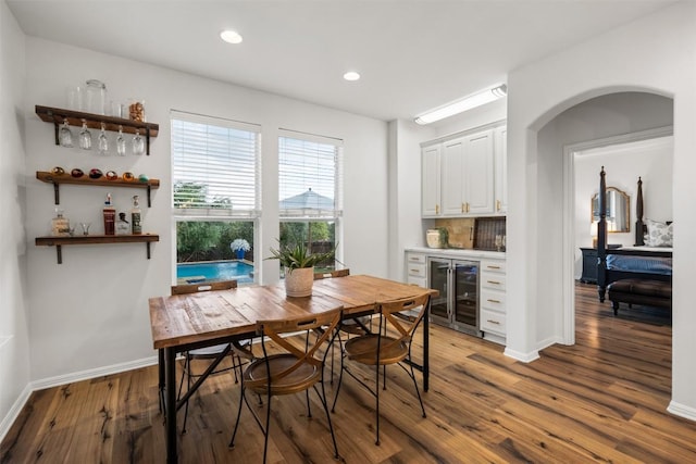 4539 Miraval Loop, Round Rock, TX 78665 - dining space featuring wine cooler, a dry bar, wood finished floors, recessed lighting, and arched walkways