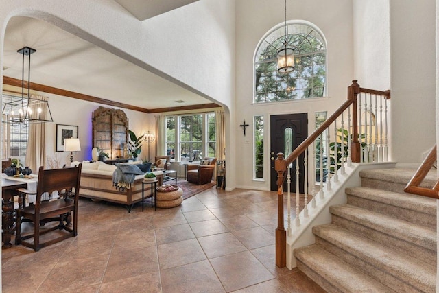1224 Fall Creek Loop, Cedar Park, TX 78613 - foyer with a chandelier, stairs, ornamental molding, a high ceiling, and arched walkways