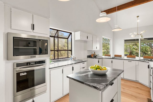 701 Terrace Mountain Dr, West Lake Hills, TX 78746 - kitchen featuring appliances with stainless steel finishes, beam ceiling, light wood-type flooring, white cabinetry, and healthy amount of natural light