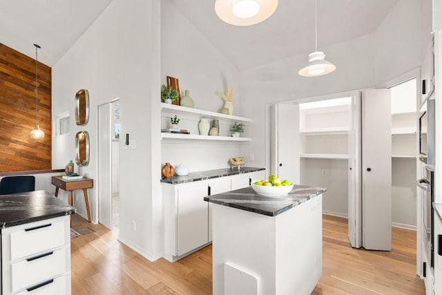 701 Terrace Mountain Dr, West Lake Hills, TX 78746 - kitchen with open shelves, white cabinets, light wood finished floors, a center island, and high vaulted ceiling
