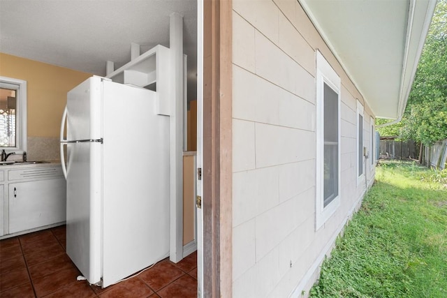 7923 Brockman St, Austin, TX 78757 - kitchen featuring freestanding refrigerator, white cabinetry, and dark tile patterned floors