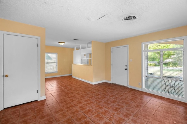 7923 Brockman St, Austin, TX 78757 - unfurnished living room featuring a textured ceiling and tile patterned floors