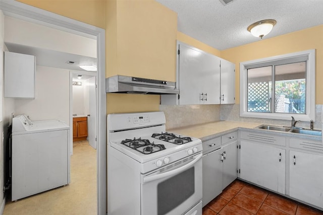 7923 Brockman St, Austin, TX 78757 - kitchen with white gas stove, under cabinet range hood, washing machine and dryer, light countertops, and a textured ceiling