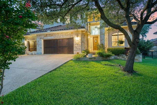view of front of property with stone siding, an attached garage, and driveway