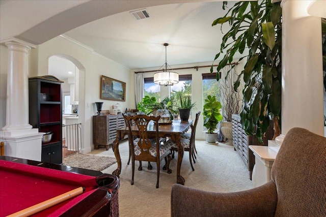 dining room with light carpet, arched walkways, decorative columns, and crown molding