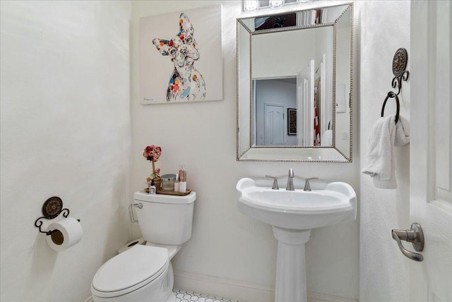 bathroom featuring toilet and baseboards