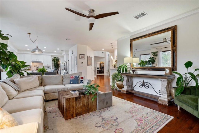 living room with a ceiling fan, wood finished floors, ornamental molding, and recessed lighting