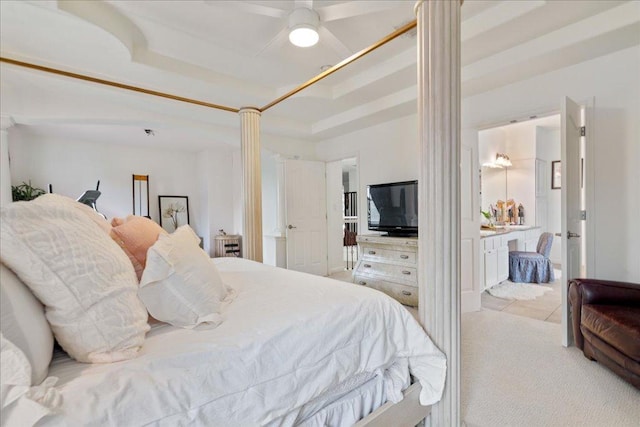 bedroom with carpet floors, ensuite bathroom, and ornate columns