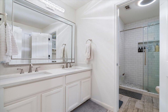 bathroom featuring a stall shower and double vanity