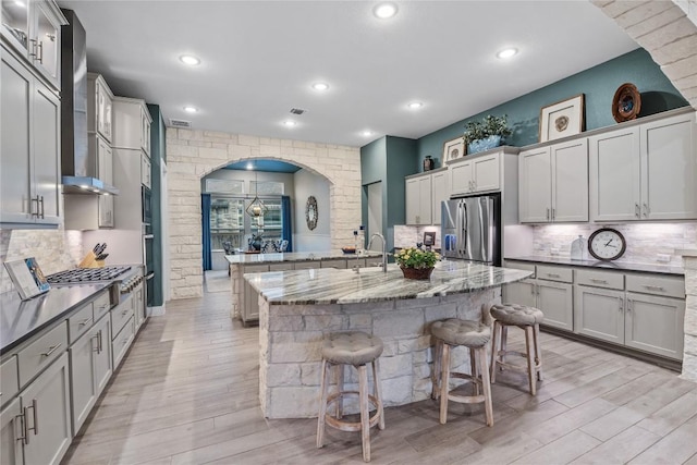 4644 Arques Ave, Round Rock, TX 78681 - kitchen with stainless steel appliances, a center island with sink, a breakfast bar area, backsplash, and recessed lighting
