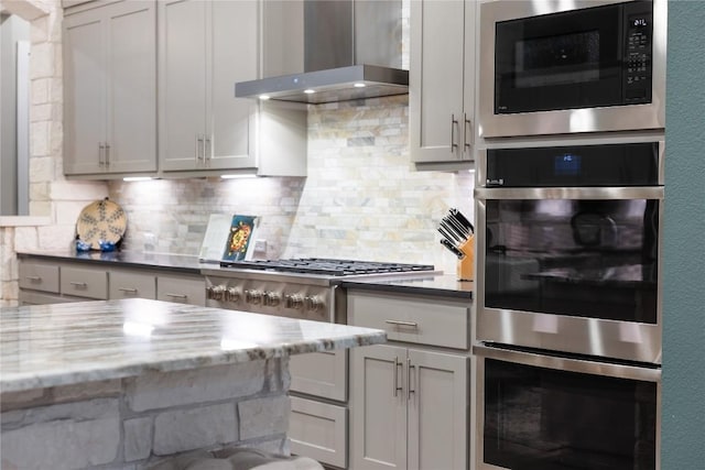 4644 Arques Ave, Round Rock, TX 78681 - kitchen featuring wall chimney exhaust hood, appliances with stainless steel finishes, backsplash, and light stone countertops
