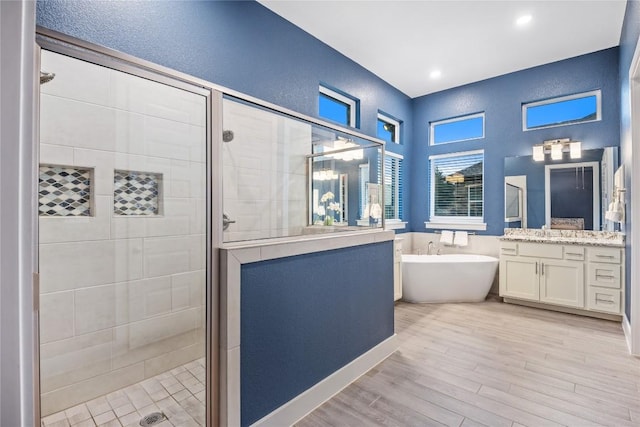 4644 Arques Ave, Round Rock, TX 78681 - full bathroom featuring a shower stall, a freestanding bath, vanity, a textured wall, and wood finished floors