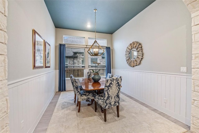 4644 Arques Ave, Round Rock, TX 78681 - dining room with light wood-style flooring, a wainscoted wall, and a chandelier