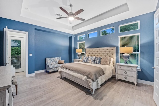 4644 Arques Ave, Round Rock, TX 78681 - bedroom with a tray ceiling, wood finished floors, and a ceiling fan