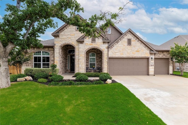 4644 Arques Ave, Round Rock, TX 78681 - french country home featuring driveway, a front lawn, an attached garage, and stone siding