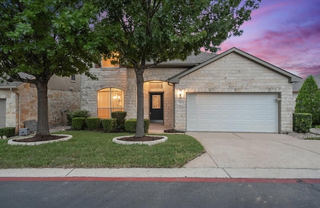 36 White Magnolia Cir, Austin, TX 78734 - view of front of property with concrete driveway, a garage, a yard, and stone siding