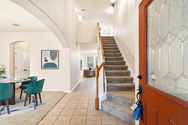 36 White Magnolia Cir, Austin, TX 78734 - entrance foyer featuring light tile patterned flooring, stairway, arched walkways, and light carpet