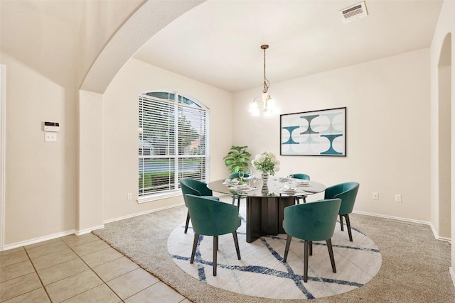 36 White Magnolia Cir, Austin, TX 78734 - carpeted dining room featuring arched walkways, a chandelier, and tile patterned flooring