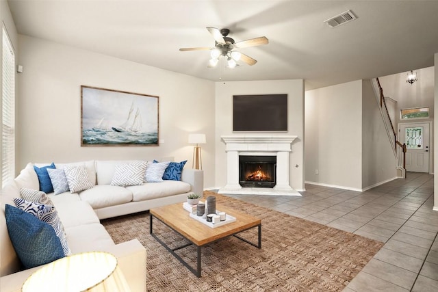 36 White Magnolia Cir, Austin, TX 78734 - tiled living area with a ceiling fan, a lit fireplace, and stairs