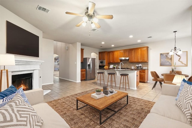 36 White Magnolia Cir, Austin, TX 78734 - living room with light tile patterned flooring, ceiling fan, recessed lighting, a chandelier, and a warm lit fireplace