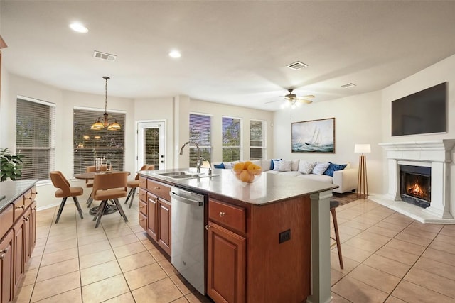 36 White Magnolia Cir, Austin, TX 78734 - kitchen featuring dishwasher, light tile patterned flooring, a lit fireplace, a kitchen bar, and open floor plan
