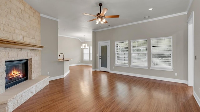 208 Rachel Loop, Burnet, TX 78611 - unfurnished living room with a fireplace, ceiling fan, wood finished floors, a chandelier, and ornamental molding