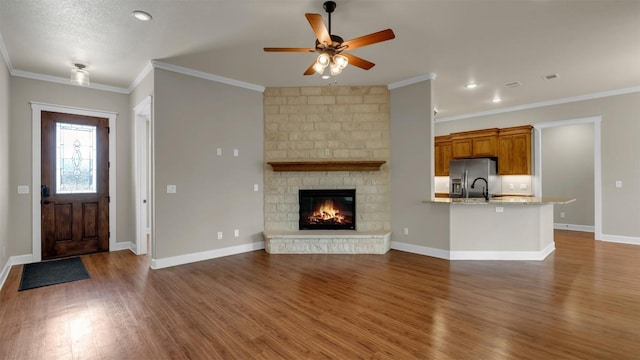 208 Rachel Loop, Burnet, TX 78611 - unfurnished living room featuring a ceiling fan, wood finished floors, crown molding, a fireplace, and recessed lighting