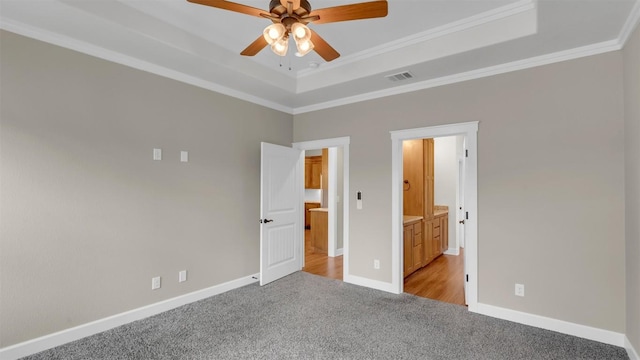 208 Rachel Loop, Burnet, TX 78611 - unfurnished bedroom with carpet flooring, a tray ceiling, ornamental molding, ensuite bath, and a ceiling fan