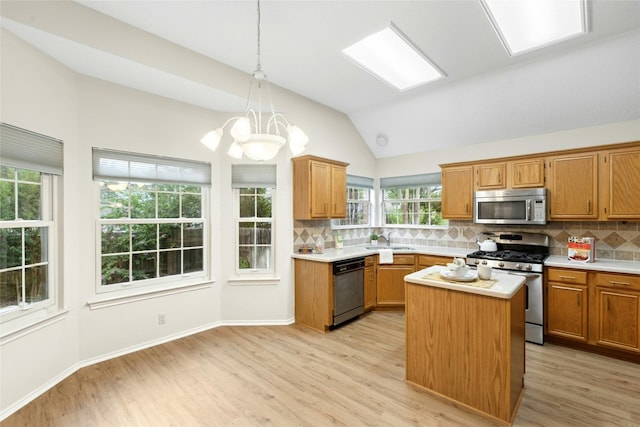1212 Dove Cir, Cedar Park, TX 78613 - kitchen featuring appliances with stainless steel finishes, light wood finished floors, lofted ceiling, light countertops, and backsplash