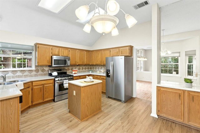 1212 Dove Cir, Cedar Park, TX 78613 - kitchen with appliances with stainless steel finishes, light wood-type flooring, light countertops, decorative backsplash, and a kitchen island