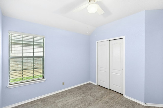 1212 Dove Cir, Cedar Park, TX 78613 - unfurnished bedroom featuring wood finished floors, multiple windows, a closet, vaulted ceiling, and a ceiling fan