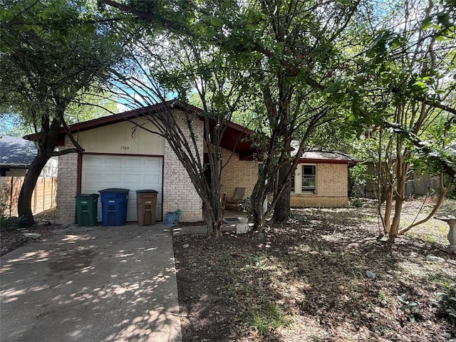1204 Dunstan Dr, Austin, TX 78745 - view of side of home featuring brick siding, driveway, and a garage