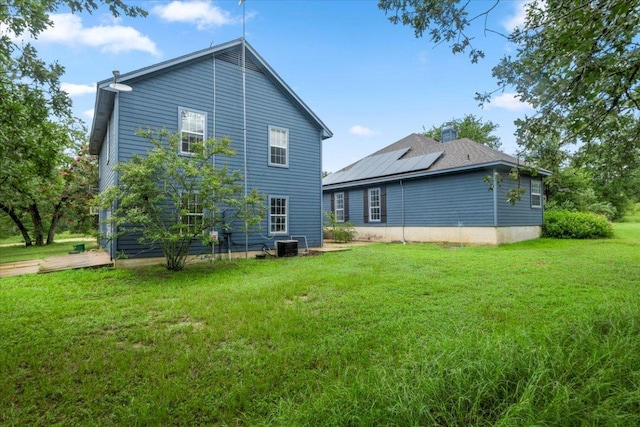 1109 Sherrill Ln, Lexington, TX 78947 - back of house featuring solar panels and a lawn
